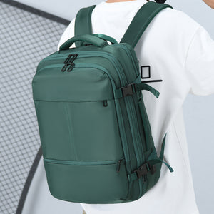 Man wearing the green 33L travel laptop backpack, side-back view