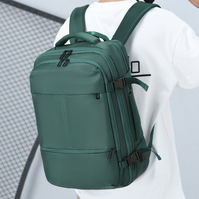 Man wearing the green 33L travel laptop backpack, side-back view